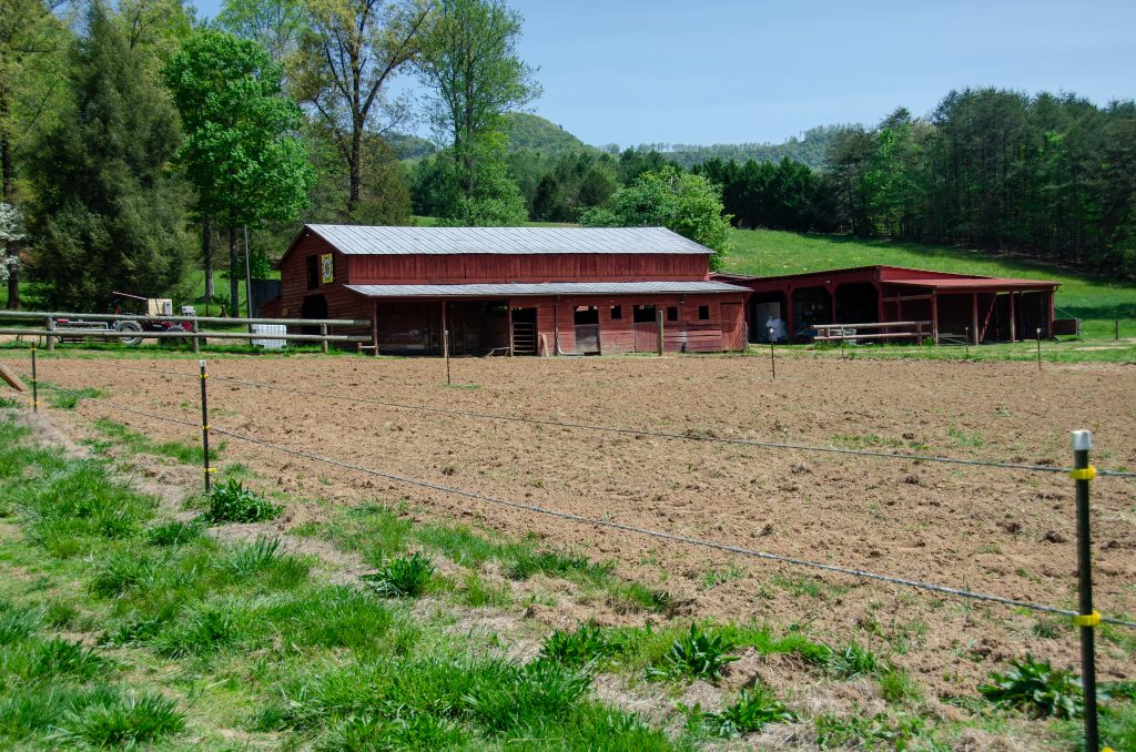 View of a farm field and red barn